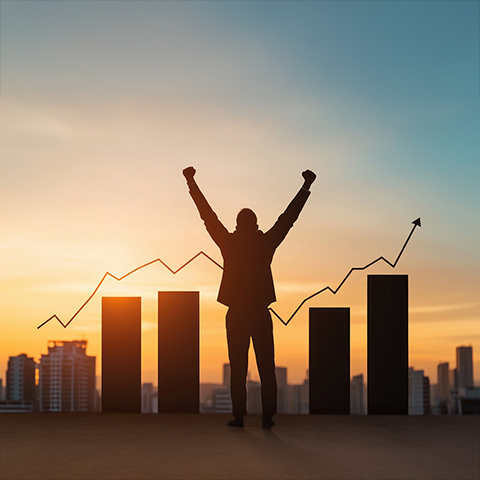 Silhouette of businessman celebrating success at sunset.